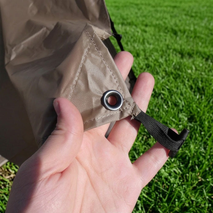 Load image into Gallery viewer, Close-up of a metal grommet and elastic toggle on a khaki Picnic Windows panel