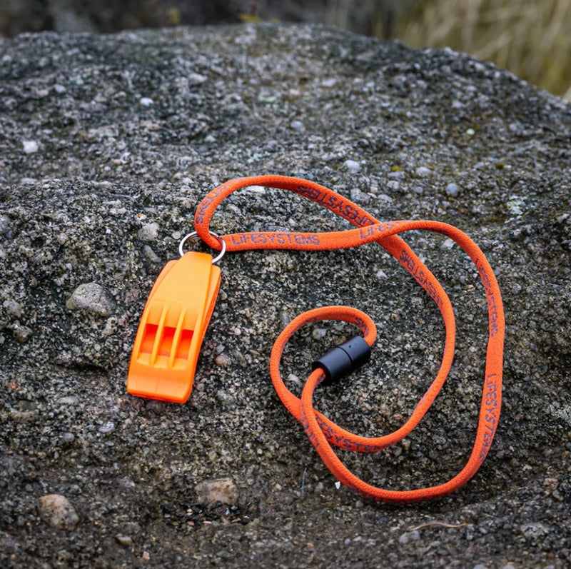 Load image into Gallery viewer, Orange whistle with lanyard on a rocky surface