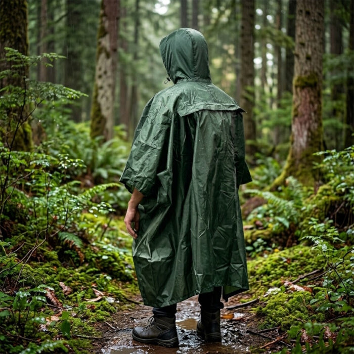 Load image into Gallery viewer, Rear view of a person in a green hooded rain poncho walking through a wet woods
