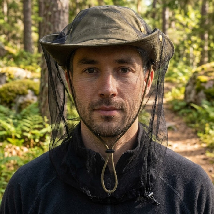 Load image into Gallery viewer, A man wearing a black midge net over a wide-brimmed hat in a sunlit forest