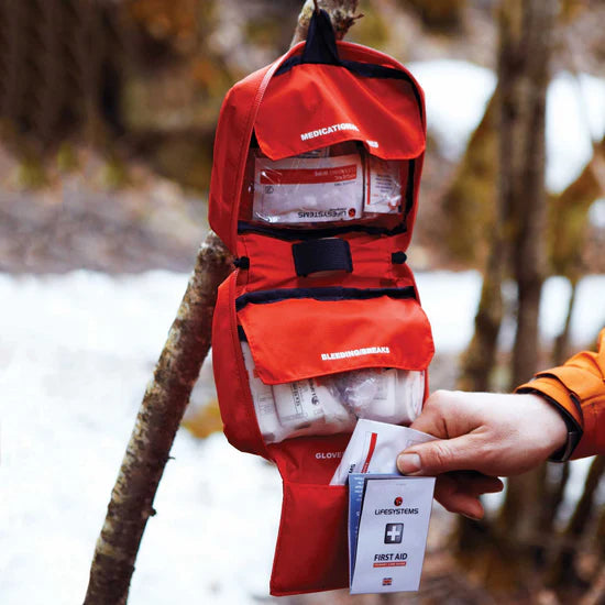 Load image into Gallery viewer, Red emergency backpack with medical supplies held by a person outdoors.
