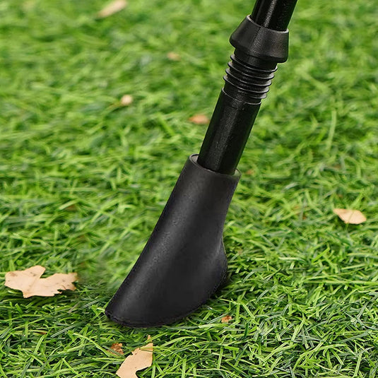 Black garden tool on grass with leaves