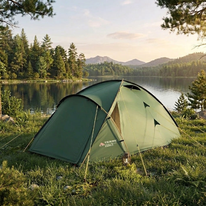 Load image into Gallery viewer, Green Terra Incognita Ksena 3 tent pitched on a grassy lakeshore with mountains
