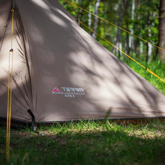 Terra Incognita Alfa 3 tent set up in a forest with yellow guylines