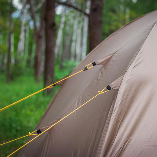 Close-up of three yellow reflective guylines tensioned on an Alfa 3 tent rainfly