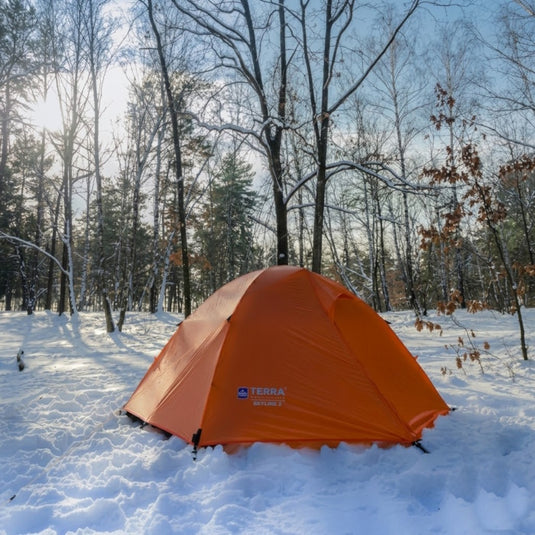 SkyLine 2 orange 2-person tent pitched in a grassy field with mountain view